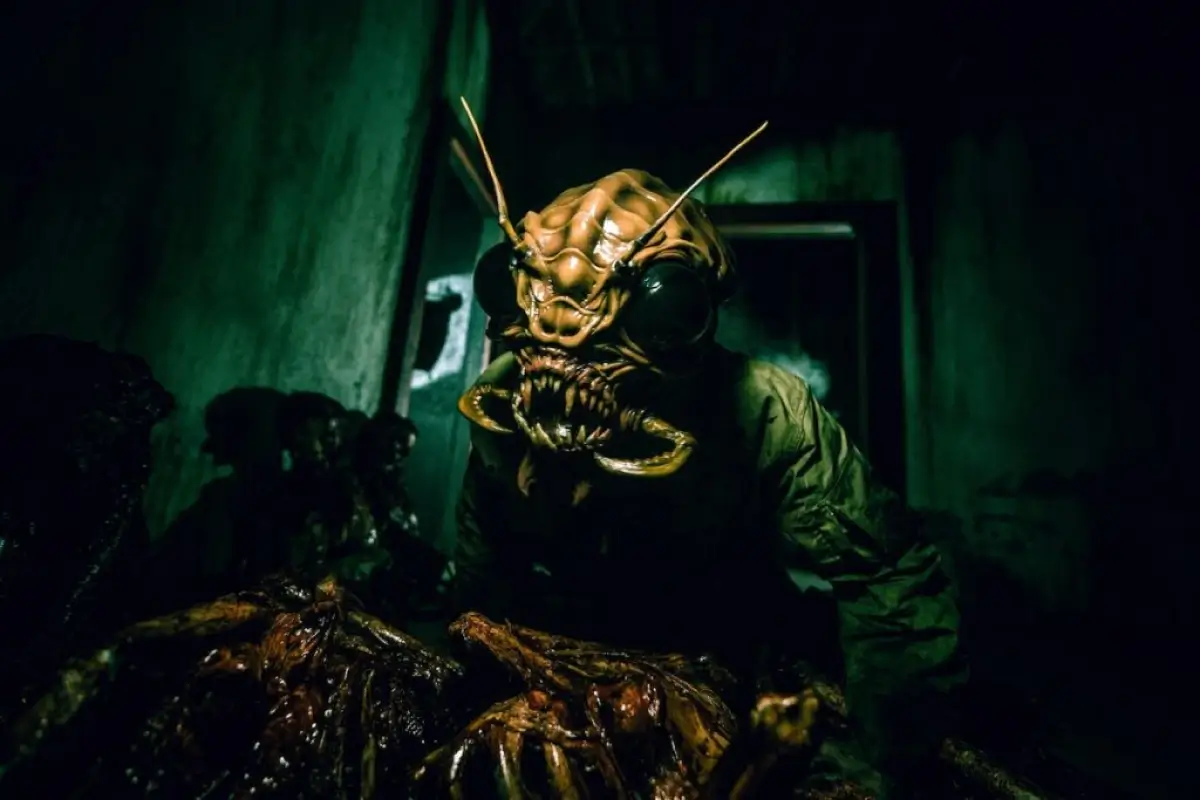 Nightmare Cleveland haunted house actor in horrifying insect creature costume lurking in a dark corridor